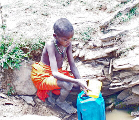 Young boy collecting drinking water for his family's use in Northern Kenya